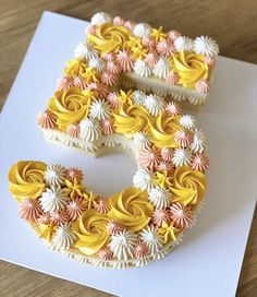 the letter e is made out of cupcakes with icing and flowers on it