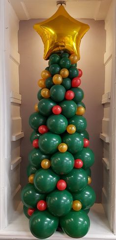 a christmas tree made out of balloons in an open refrigerator with a gold star on top