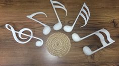 music notes are arranged in the shape of musical notes on a wooden table with rope