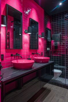 a bathroom with two sinks and pink tiles on the walls, along with black counter tops