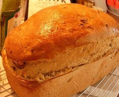 a loaf of bread sitting on top of a cooling rack next to an empty bottle