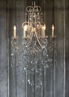 a chandelier hanging from a wooden wall