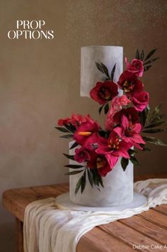 a white cake with red flowers on top and the words prop options written above it