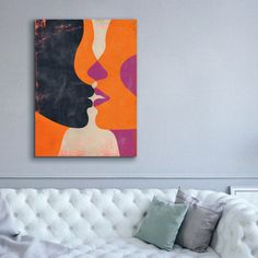 a living room with a white couch and painting on the wall above it's head