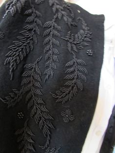 an embroidered piece of cloth with leaves on it