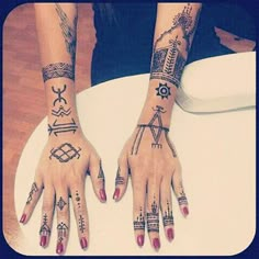 two woman's hands with tattoos on them sitting on a white chair and one has her hand in the shape of an arrow