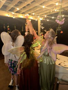 three girls dressed as tinkerbells at a party