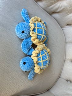 two small stuffed animals sitting on top of a couch