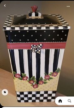 a black and white striped box sitting on top of a wooden table next to a wall