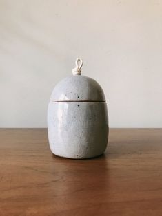 a white ceramic container sitting on top of a wooden table