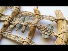 several pieces of driftwood tied together with rope and stones on them, sitting on a white surface