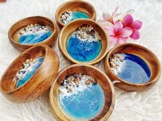 four wooden bowls with blue and white designs on them sitting on a furnishing