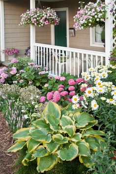 a house with lots of flowers in front of it