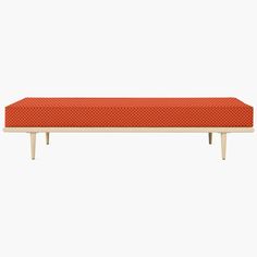 an orange bench sitting on top of a white table