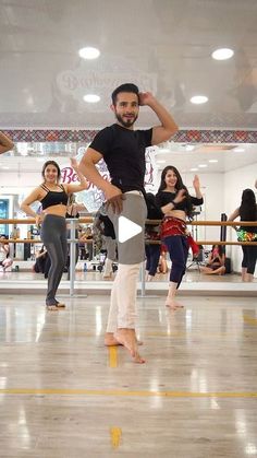 a man standing on top of a wooden floor in front of other people doing dance