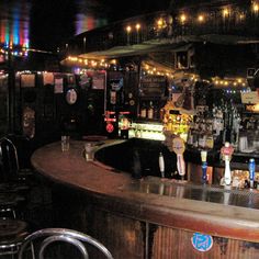 a dimly lit bar with chairs and lights