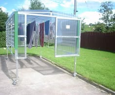 an outdoor area with clothes hanging out to dry in the sun, and green grass