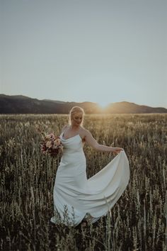 a woman in a white dress is standing in a field