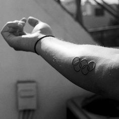 black and white photo of a person's arm with an olympic symbol on it