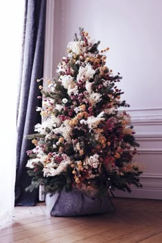 a fake christmas tree in a pot on the floor