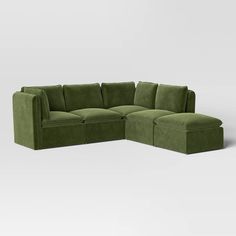 a green sectional couch sitting on top of a white floor