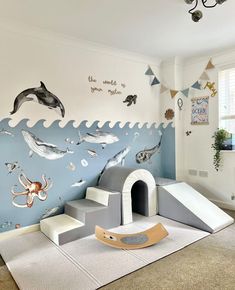 a child's playroom with an ocean theme on the wall