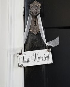 a sign that says just married hanging on a door handle with ribbon attached to it