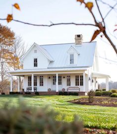 a white house sitting on top of a lush green field