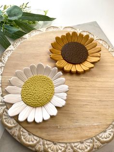 two flowers sitting on top of a wooden table