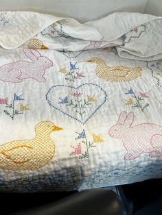 an unmade bed with some bunny and duck designs on it