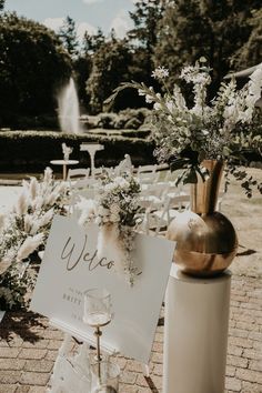 an outdoor ceremony setup with white flowers and greenery