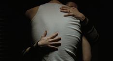 two hands on the back of a person's body, with their arms wrapped around each other