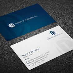 two business cards on the ground, one is blue and white with a logo for donald hudson