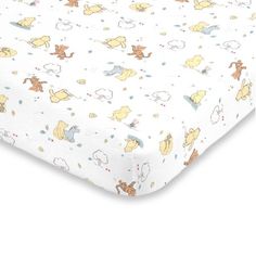 the winnie the pooh crib sheet is made with white sheets and yellow trim