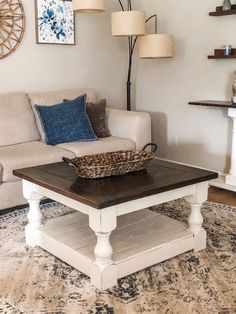 a living room with a couch, coffee table and lamps on the wall above it