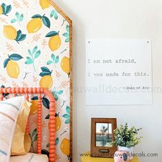 a bed room with a neatly made bed and a sign on the wall above it