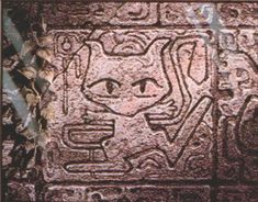 an image of a face carved into the side of a stone wall with writing on it