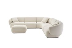 a white sectional couch with two chairs and one footstool on the back side