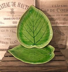 a green leaf shaped dish sitting on top of a wooden table