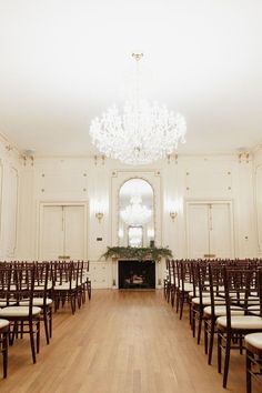 an empty ballroom with chairs and chandelier