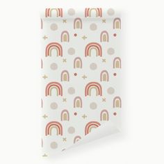 a white wallpaper with rainbows and crosses on it, next to a roll of paper