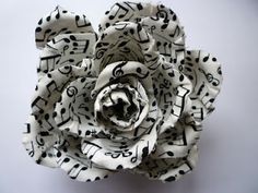 a paper rose with musical notes on it's petals and the center is black and white