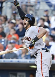 a baseball player holding a bat on top of a field in front of a crowd