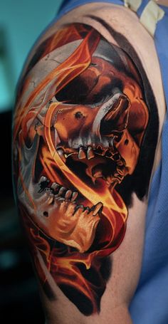 a man with a skull and flames tattoo on his arm