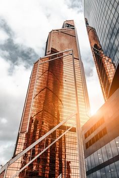 the sun shines brightly behind two skyscrapers in new york's financial district