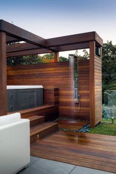 an outdoor hot tub in the middle of a wooden decked area with a shower