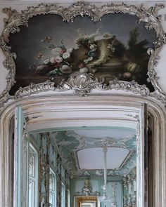 an ornately decorated hallway with blue walls and white trim, painted on the ceiling