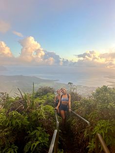 two women walking up stairs in front of the ocean