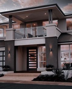 a two story house with glass balconies on the second floor and stairs leading up to it