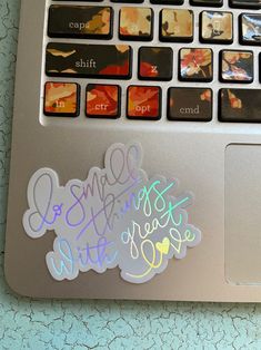 an open laptop computer sitting on top of a table covered in stickers and writing